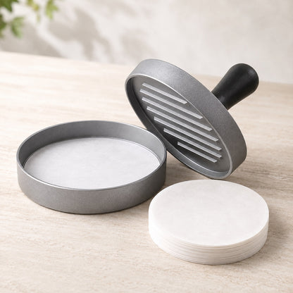 Svart burgerpresse med runde bakepapirark