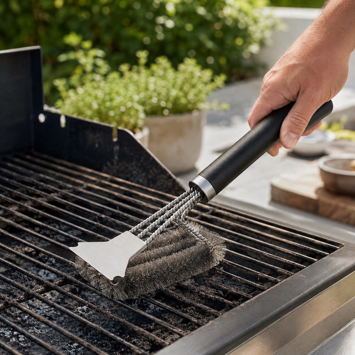 Grillbørste med skraber brugt på en grillrist