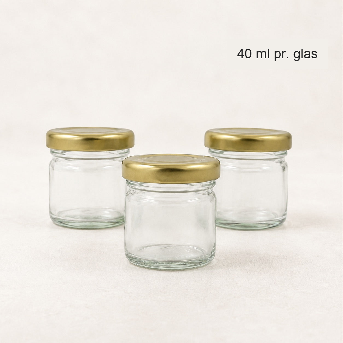 Tre små syltetøjsglas med guldfarvede låg, 40 ml pr. glas