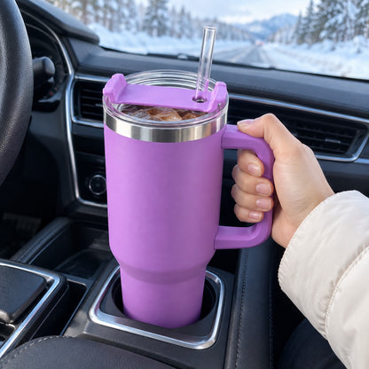 Lilla termokopp med håndtak og sugerør i koppholderen i bilen en vintermorgen