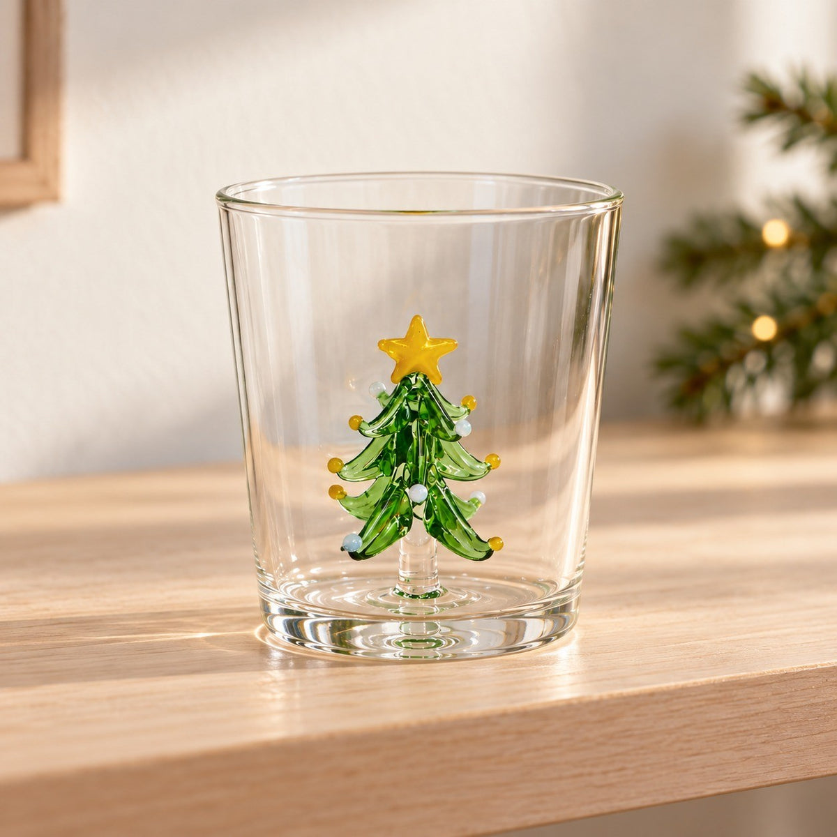 Ett juletreglass 300 ml med grønt glasstre og gul stjerne inni, stående på en hylle