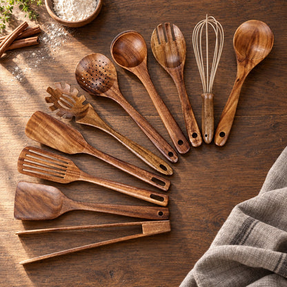 All ten teak kitchen utensils laid out on a dark oak table