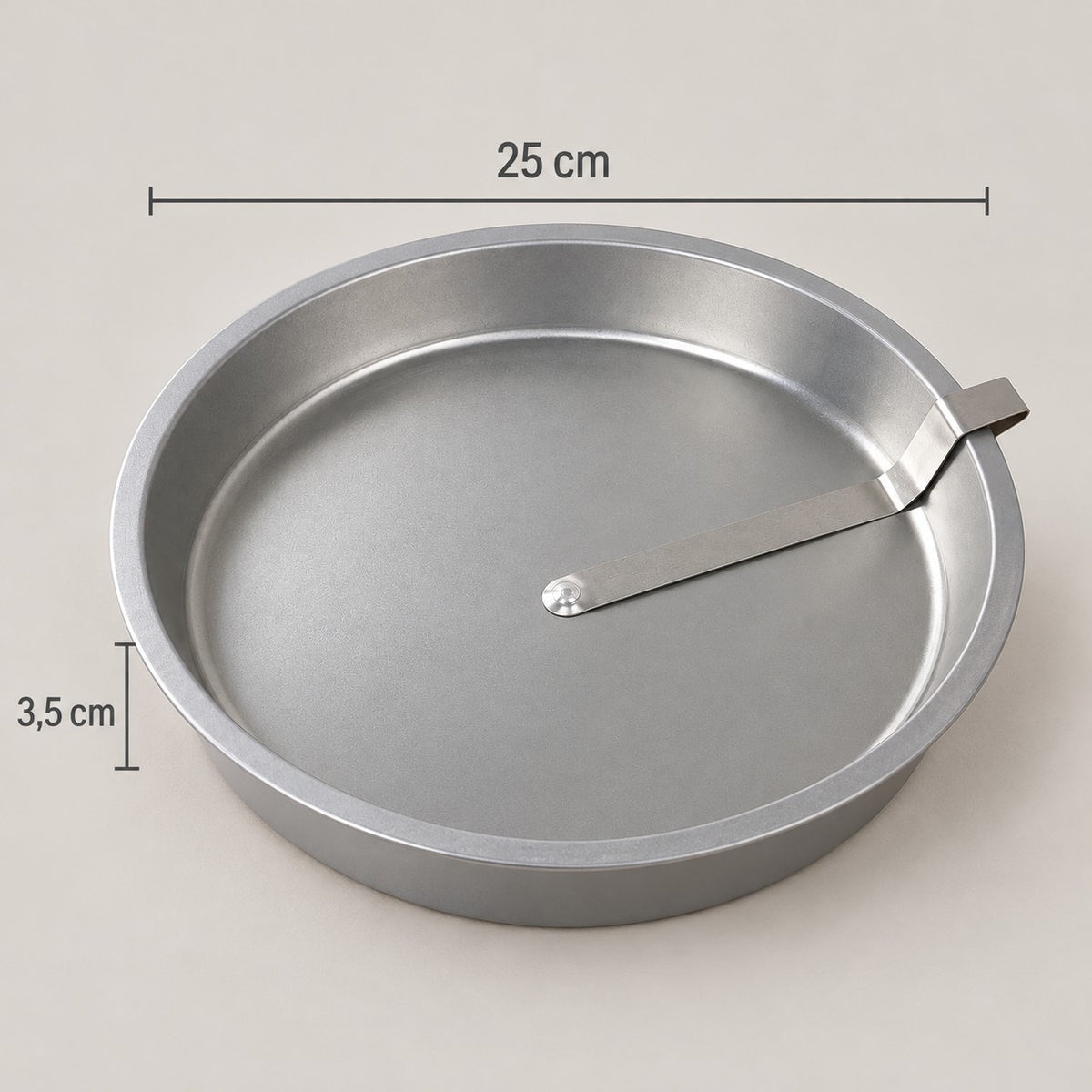 Slippa cake tin with dimensions: 25 cm in diameter and 3.5 cm high, with the release lever on the base